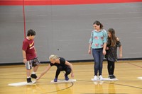 middle school student helps fellow student in game of lava