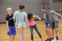 middle school students learn team work skills by playing a game of lava