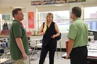 teacher talks with two guardians at middle school open house
