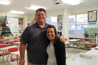 teacher smiles for a picture with parent who is a c v coach during open house