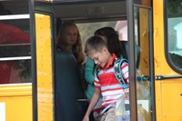 boy smiles getting off the bus to go to first day of school at chenango bridge elementary