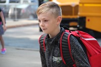 boy smiles walking towards chenango bridge elementary school