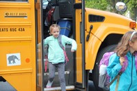 girl smiles getting off her bus at chenango bridge elementary on the first day of school