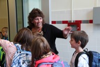 principal mary beth hammond waves to students at the entrance of chenango bridge elementary