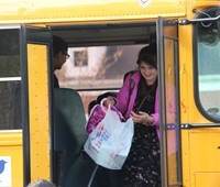 student exits school bus smiling