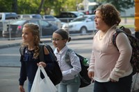 three girls smile walking towards chenango bridge elementary after getting off bus on first day of s