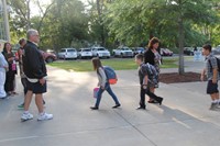 wide shot of students walking towards chenango bridge elementary school on first day