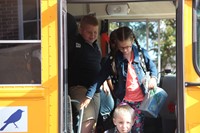 students smile getting off bus