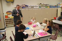 students show superintendent gill their coloring