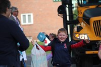 boy smiles widely after getting off the bus on first day of school at port dickinson elementary