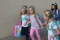 girl students smile holding hands walking toward port dickinson