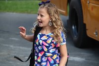 girl waves hi getting off bus on first day of elementary school at port dickinson elementary
