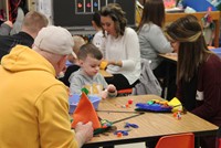 students and adults working on scarecrow hats