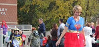 students and teacher in halloween costumes walking