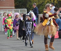 students and teacher parading in halloween costumes