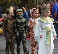 four students wearing halloween costumes