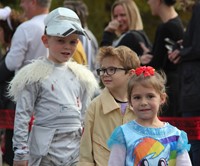 three students wearing halloween costumes