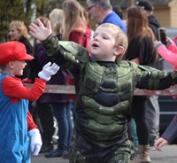 students waving wearing halloween costume