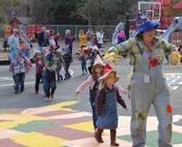 students and teacher parading wearing scare crow hats