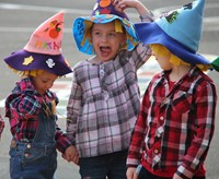three students wearing scare crow hats