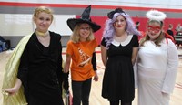 four students wearing halloween costumes