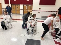 students mummifying students with toilet paper