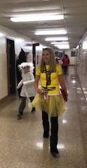 teacher and students wearing costumes walking down hall