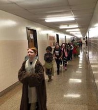 students wearing costumes walking down hallway