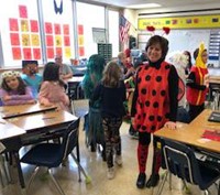 students and teacher wearing halloween costumes in classroom