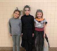 three students dressed in halloween costumes