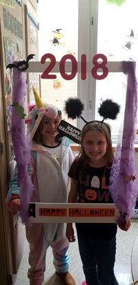 two students in costumes with photo sign