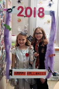 two students in costume with photo sign