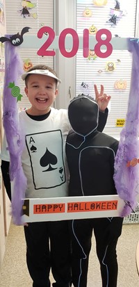 two students wearing costumes at photo booth sign