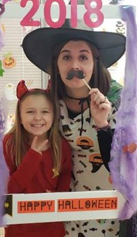 student and teacher in costume at halloween photo booth sign