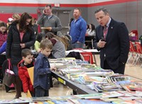 superintendent and students at book table