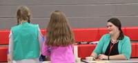 students and teacher at activity table