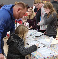 students and adults at activity station