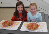 two students smiling with thanksgiving treats