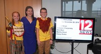 students and teacher by welcome sign