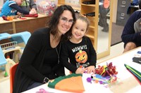 woman and student smile at pre k family day