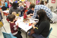 people working on making scarecrow hats at pre k family day