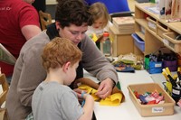 woman working with child to make scarecrow hat