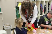 woman helping girl cut felt scarecrow hat