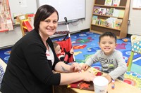 woman and student smile for a picture at pre k family day