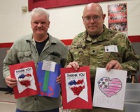 two veterans holding thank you cards