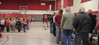 student signing patriotic song in front of veterans