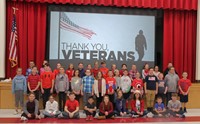 students in front of thank you veterans power point slide