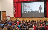 wide shot of student speaking at veterans day assembly