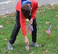 student placing flag in ground