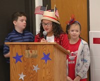 up close of student speaking wearing american flag hat at veterans day assembly